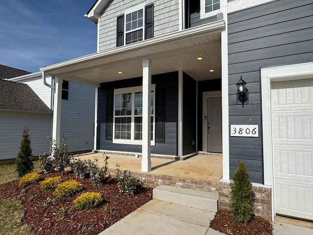 property entrance featuring covered porch and an attached garage