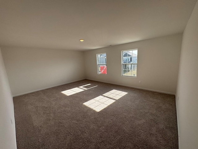 carpeted spare room featuring baseboards