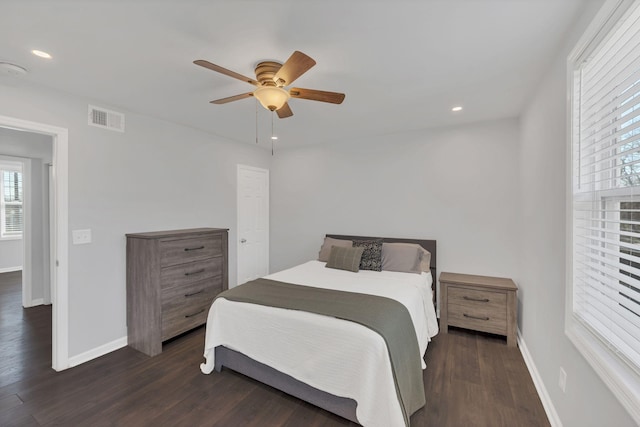 bedroom featuring visible vents, ceiling fan, dark wood-type flooring, and baseboards