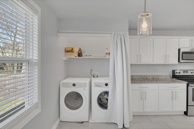 laundry area with laundry area, washing machine and dryer, and marble finish floor