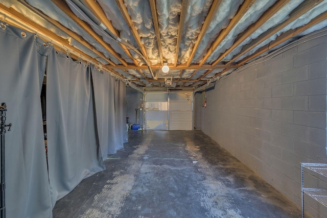 basement with a garage and concrete block wall