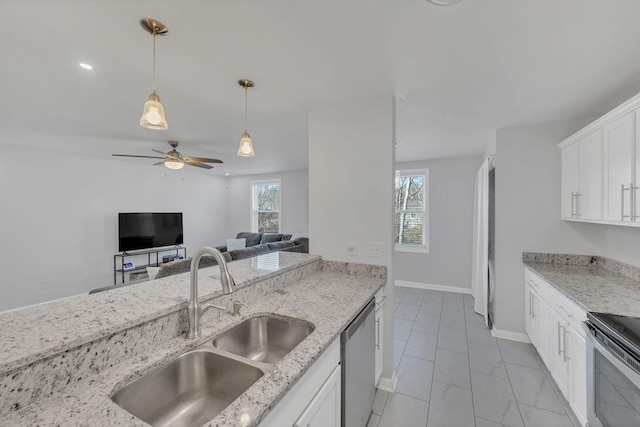 kitchen featuring a sink, light stone counters, appliances with stainless steel finishes, and white cabinets