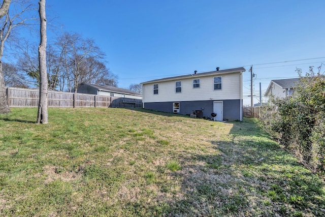 back of house with a lawn and a fenced backyard