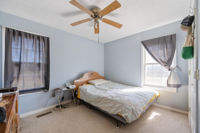 bedroom with carpet flooring, baseboards, visible vents, and ceiling fan