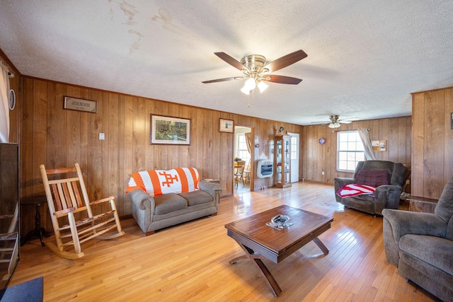 living room featuring a textured ceiling, ceiling fan, and hardwood / wood-style flooring