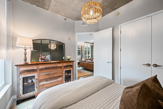 bedroom with visible vents, baseboards, an inviting chandelier, and a closet