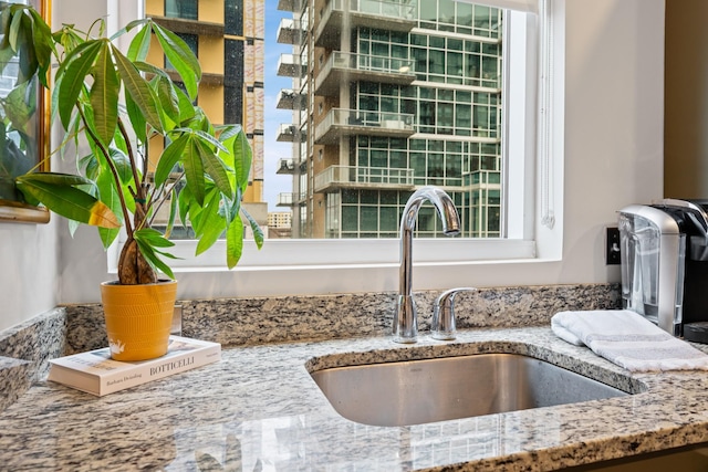 interior details with light stone counters and a sink