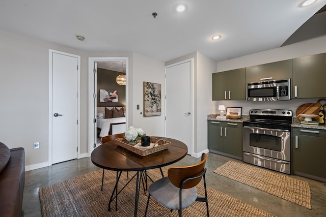 kitchen with light stone counters, baseboards, concrete floors, recessed lighting, and stainless steel appliances