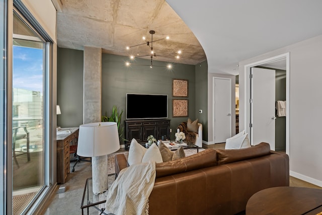 living room with baseboards, concrete flooring, and a chandelier