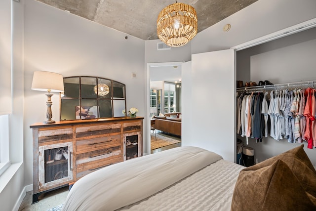 bedroom featuring a closet, visible vents, baseboards, and a notable chandelier