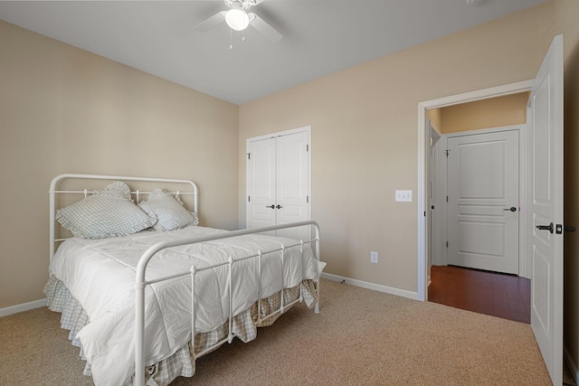 bedroom with a closet, baseboards, ceiling fan, and carpet flooring