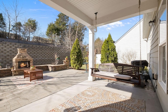 view of patio / terrace featuring fence and an outdoor stone fireplace