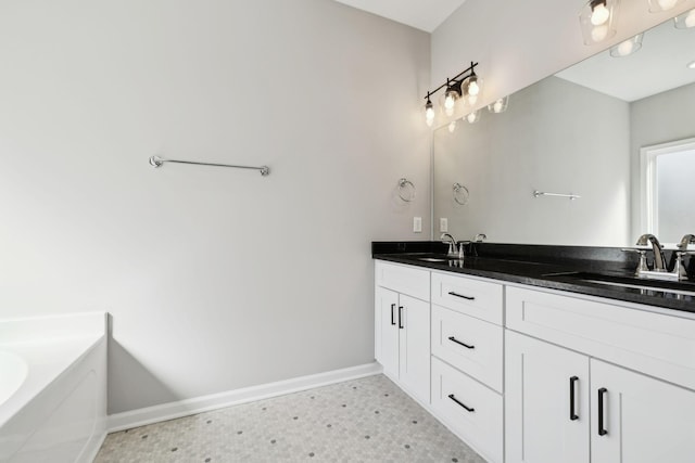 bathroom with double vanity, a tub, baseboards, and a sink