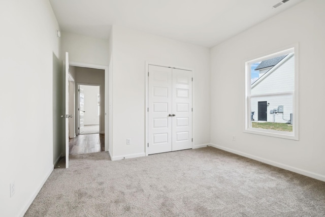 unfurnished bedroom with a closet, baseboards, and carpet flooring