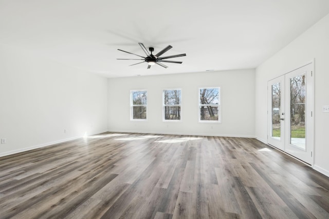 empty room featuring french doors, baseboards, ceiling fan, and wood finished floors