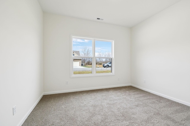 carpeted empty room featuring visible vents and baseboards