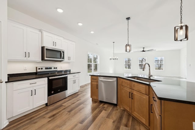 kitchen with a sink, dark countertops, and appliances with stainless steel finishes