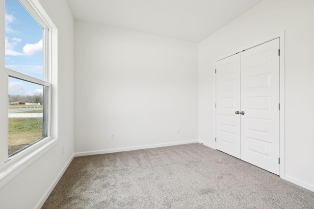 unfurnished bedroom with a closet, baseboards, and carpet floors