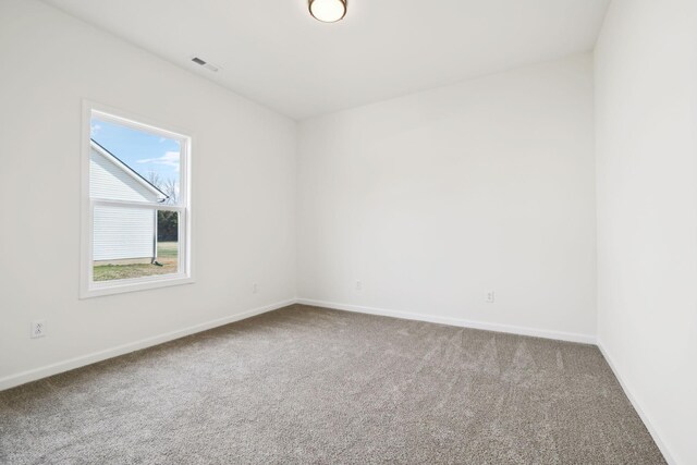 carpeted empty room with visible vents and baseboards