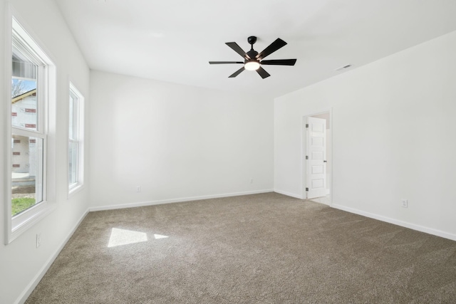 carpeted empty room with visible vents, ceiling fan, and baseboards