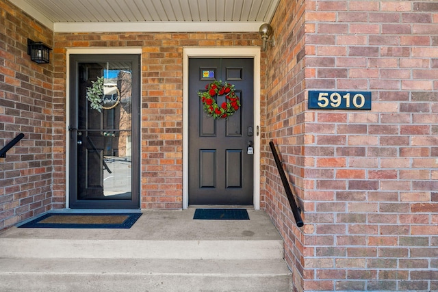 entrance to property featuring brick siding