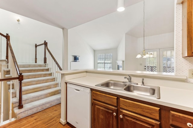 kitchen with a healthy amount of sunlight, dishwasher, light countertops, and a sink