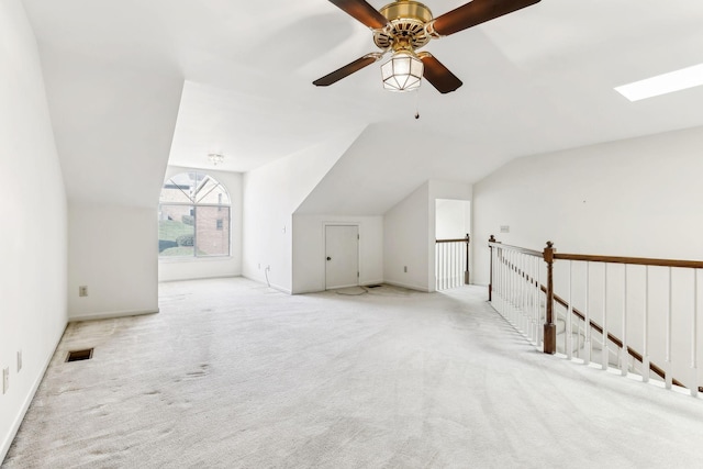 additional living space with lofted ceiling with skylight, visible vents, and carpet