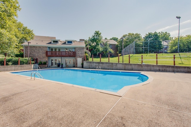 view of swimming pool featuring a fenced in pool, fence, french doors, a yard, and a patio