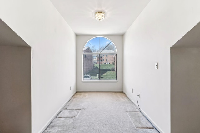 spare room with baseboards and carpet floors