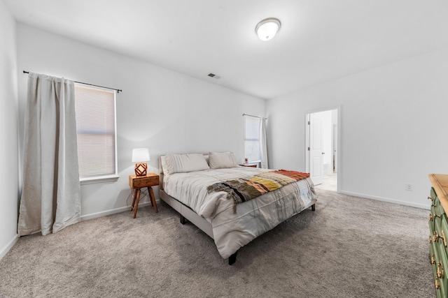 carpeted bedroom featuring visible vents and baseboards