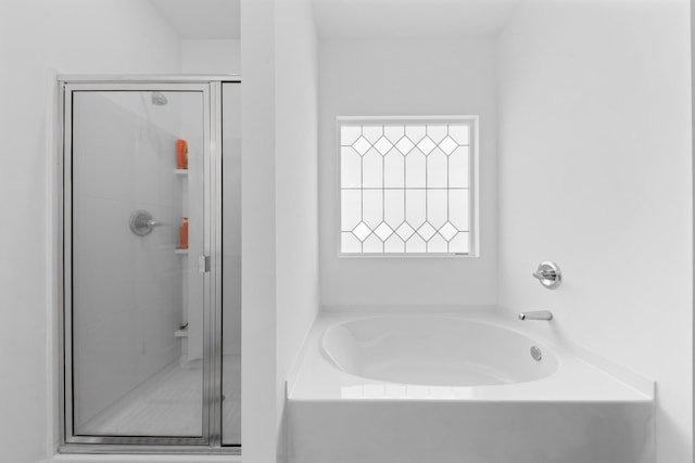 bathroom with a shower stall and a garden tub