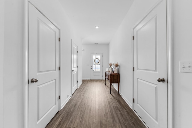 hallway with dark wood finished floors and baseboards