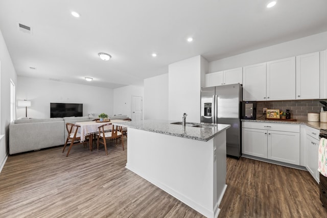 kitchen featuring a sink, light stone countertops, dark wood-style flooring, and white cabinetry