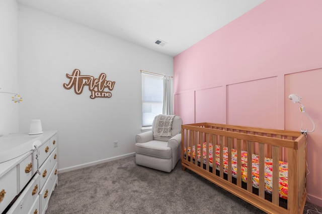 carpeted bedroom with a crib, a wainscoted wall, a decorative wall, and visible vents