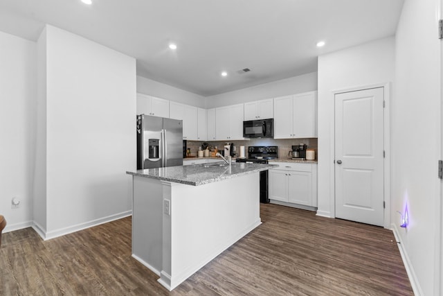 kitchen featuring light stone countertops, black appliances, dark wood-type flooring, white cabinetry, and tasteful backsplash