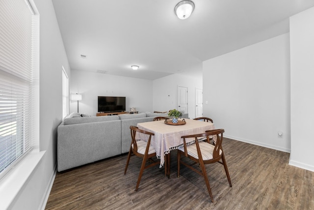 dining area featuring baseboards and dark wood-style flooring