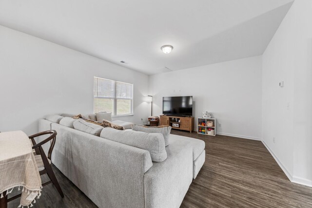 living area featuring baseboards and dark wood-style flooring