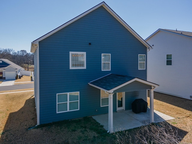 back of property with a yard and a patio area