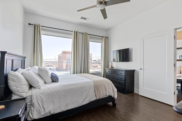 bedroom featuring visible vents, a ceiling fan, and dark wood-style flooring