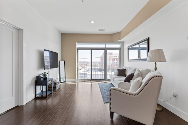 living area featuring visible vents, baseboards, and dark wood finished floors