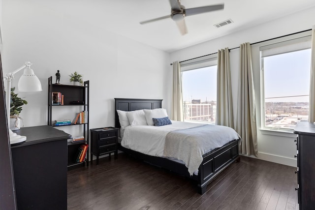 bedroom featuring dark wood finished floors, visible vents, multiple windows, and baseboards