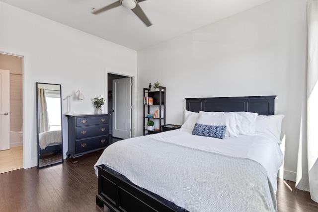 bedroom featuring baseboards, ensuite bath, ceiling fan, and dark wood-style flooring