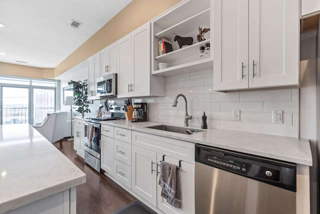 kitchen featuring visible vents, a sink, tasteful backsplash, white cabinetry, and stainless steel appliances