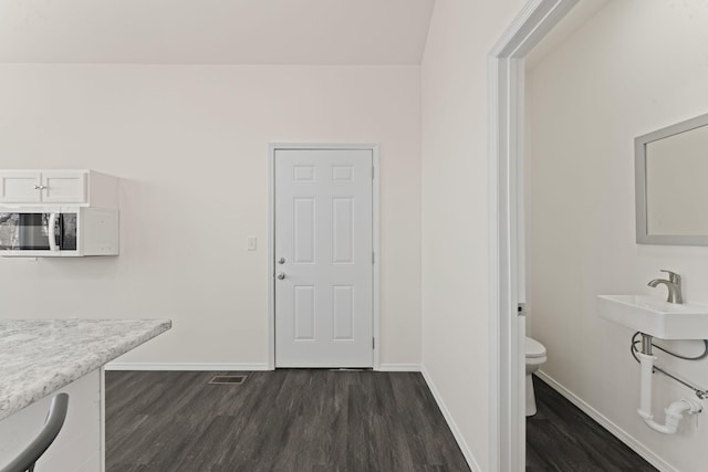 dining area with dark wood-type flooring, visible vents, and baseboards