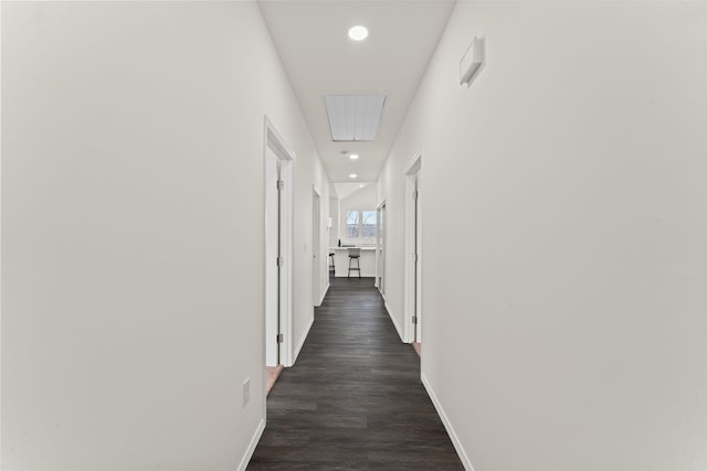 hallway featuring dark wood finished floors, recessed lighting, and baseboards