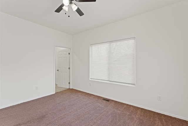 empty room featuring visible vents, ceiling fan, baseboards, and carpet floors