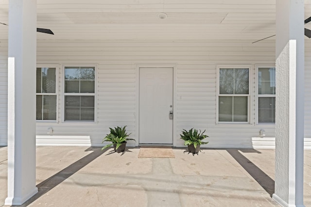 view of exterior entry with a patio