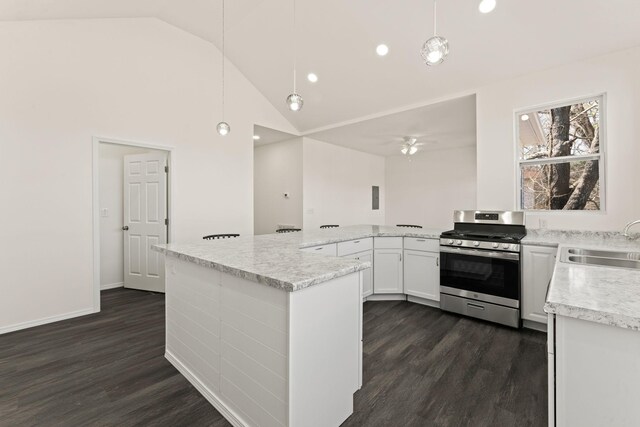 kitchen with a sink, decorative light fixtures, white cabinetry, stainless steel range with gas stovetop, and dark wood-style flooring