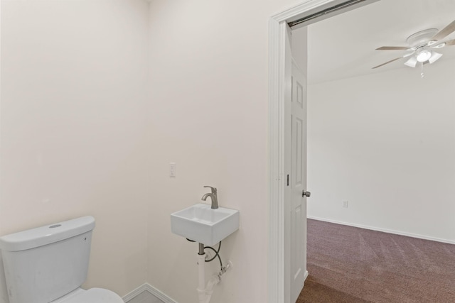 bathroom with a sink, baseboards, toilet, and a ceiling fan