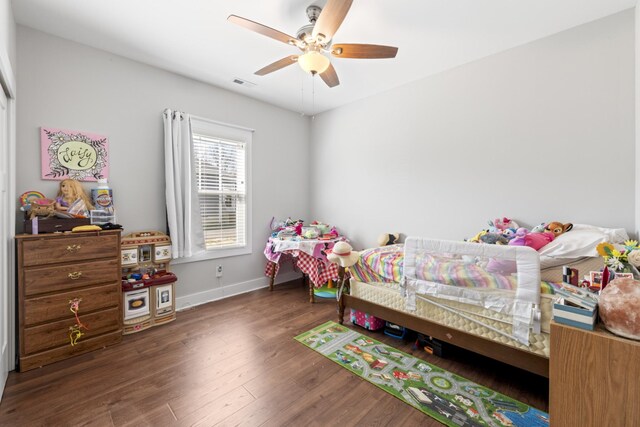 bedroom with ceiling fan, visible vents, baseboards, and wood finished floors